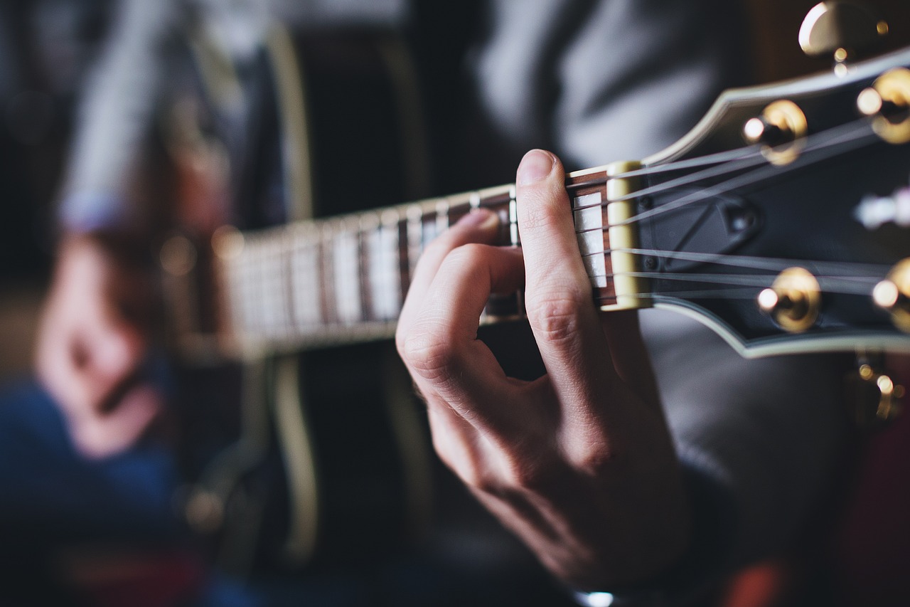 headerbild eines musikers bei gitarre spielen